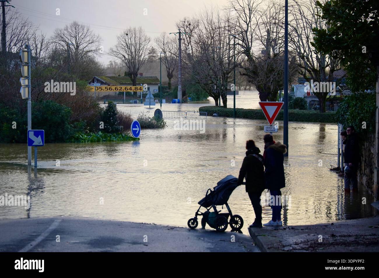 People look at a flooded street in Cadillac-sur-Garonne as severe ...