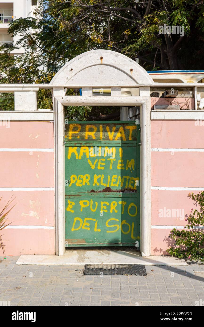 Private entry for clients of Puerto del Sol. Yellow spray paint set on a green door at Shetitorja e Plazhit beach boulevard in Durrës, Albania. Stock Photo