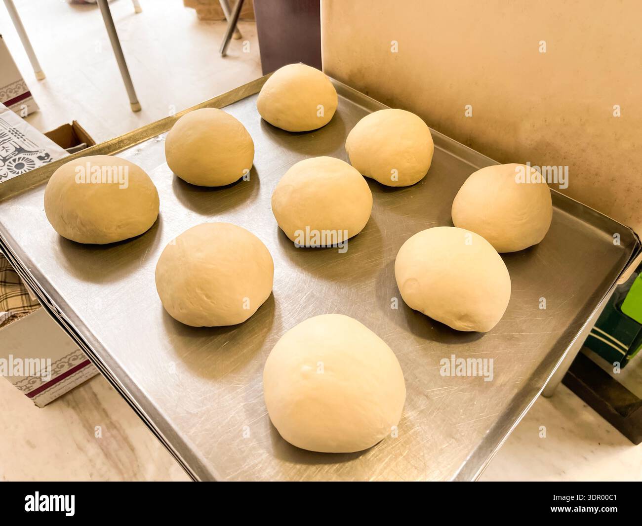 Homemade bread dough balls on a baking tray and dough kneading process in a mixer. - Smartphone Captured Stock Image