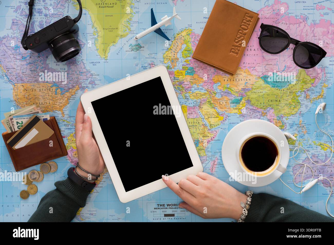Travel Planning With a Tablet and Essentials on a World Map in a Cozy Workspace Stock Photo