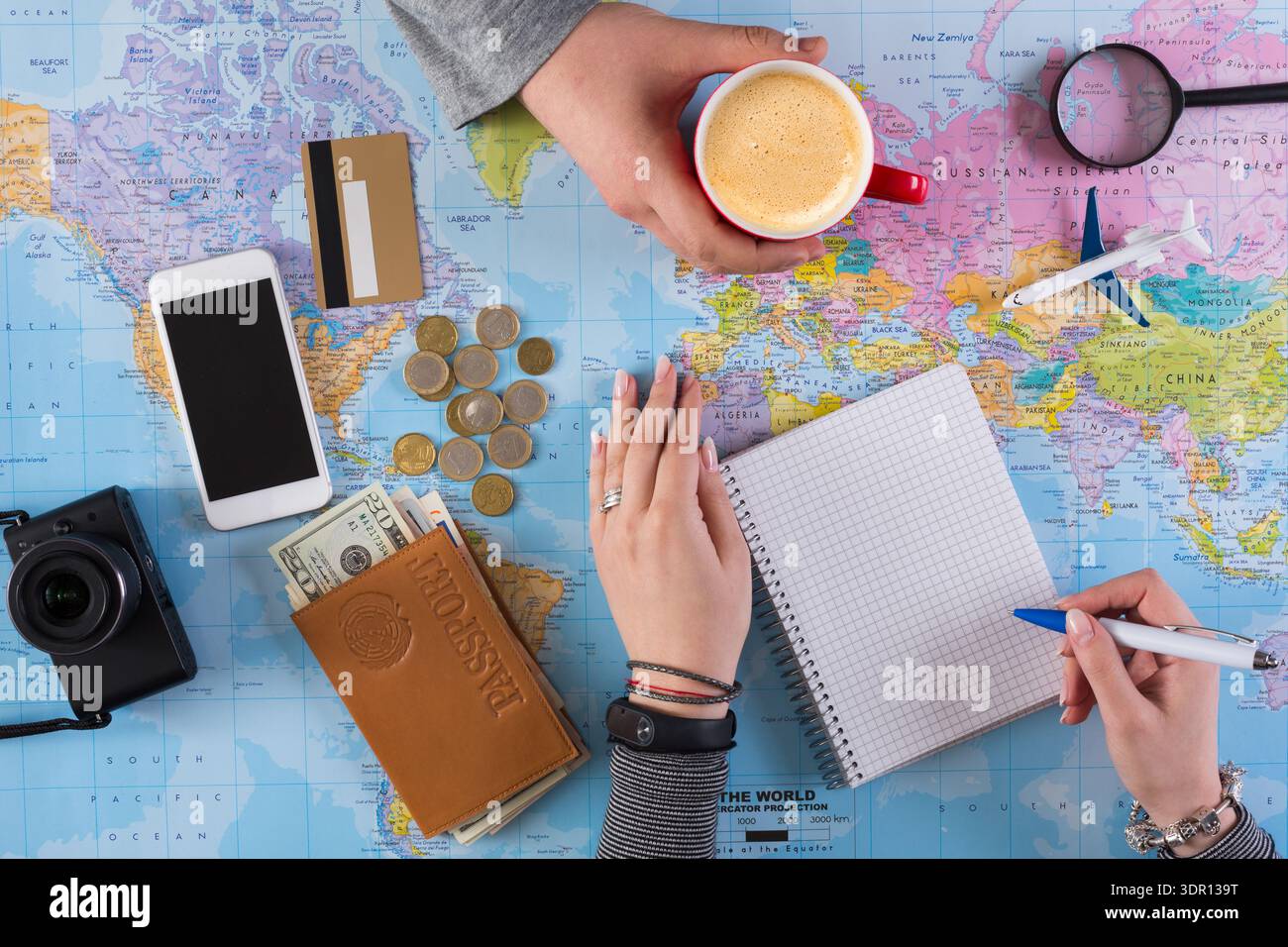 Planning a Trip With Maps, Notes, and Coffee in a Busy Workspace Stock Photo