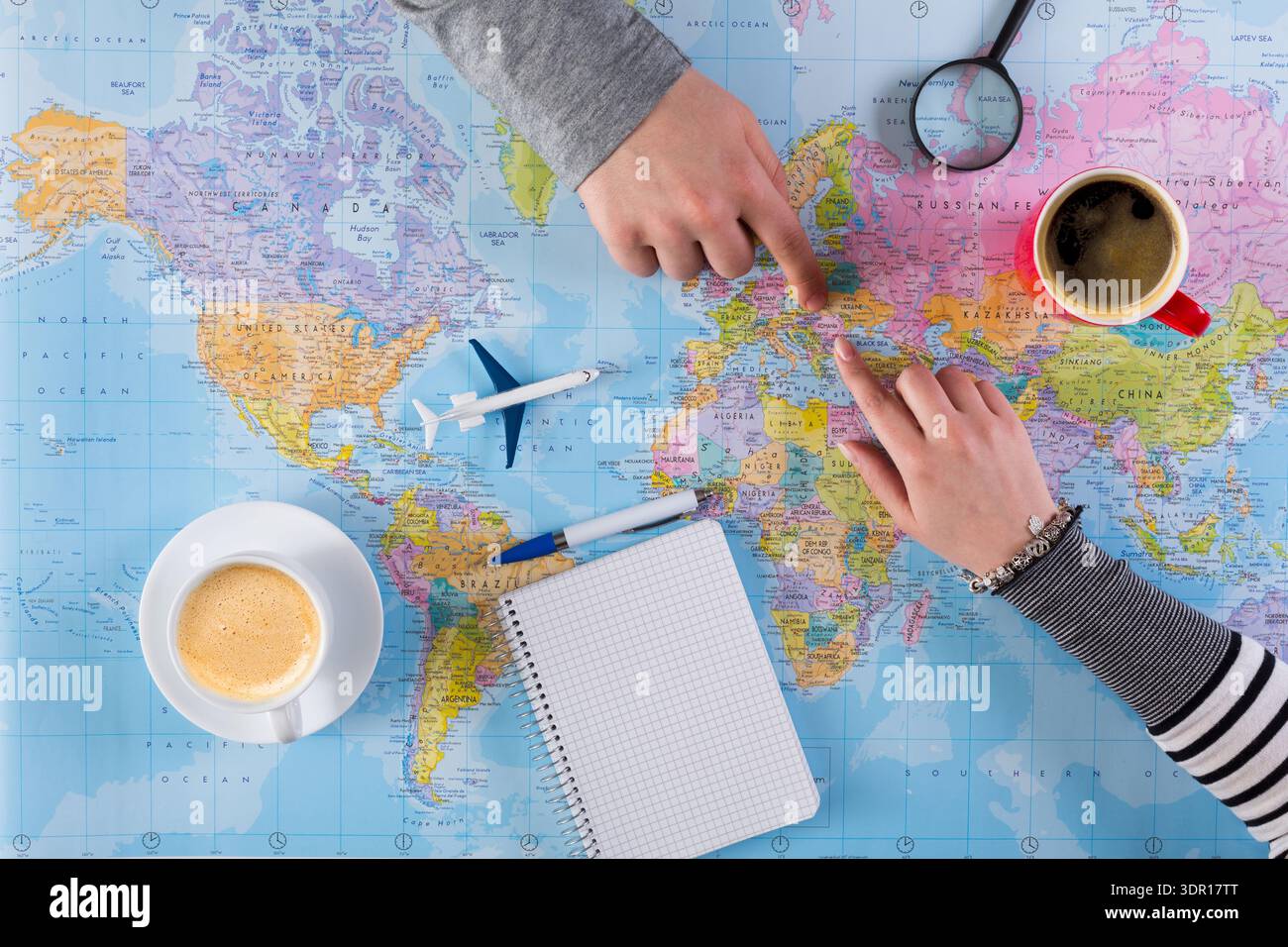 Planning a Trip With Maps, Coffee, and Notes on a Table Stock Photo