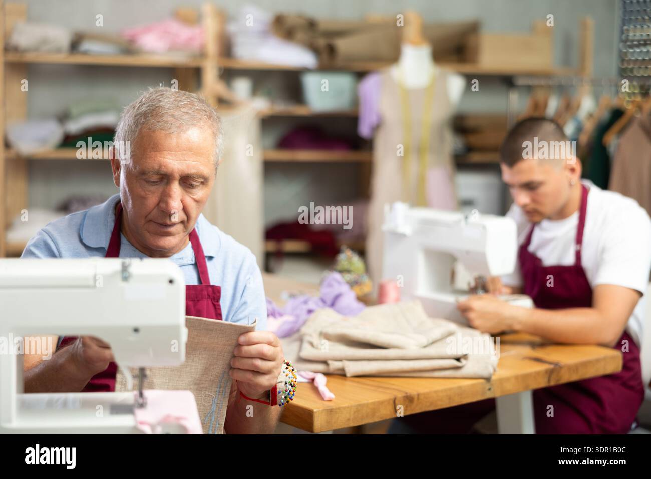 Two male tailors working with fabric Stock Photo