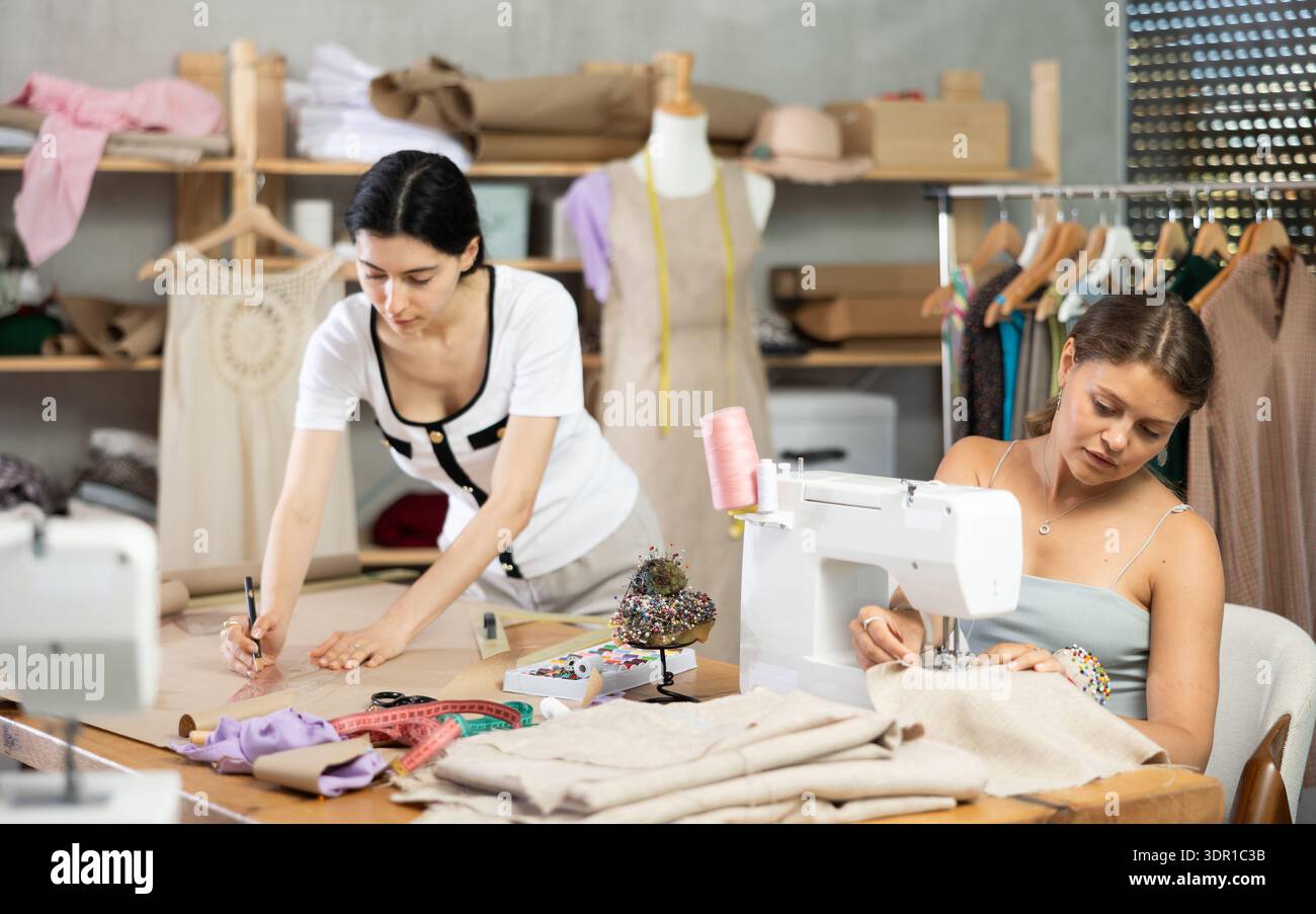 Two female tailors working on custom garment in studio Stock Photo