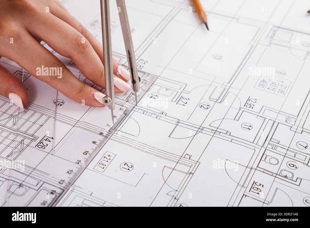 Hands Using Compass on Architectural Drawing to Create Accurate Measurements and Designs Stock Photo