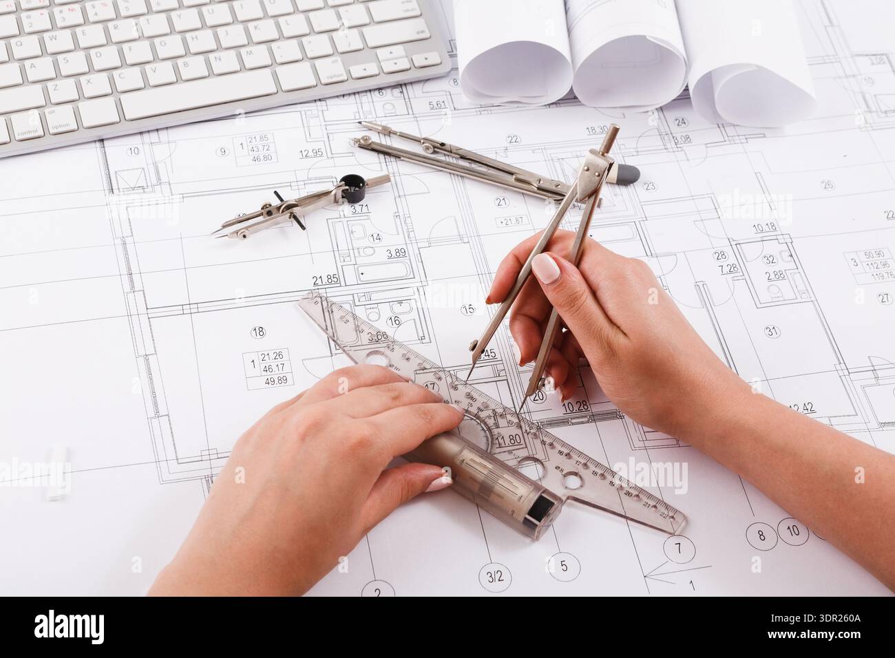 Hands Creating a Technical Drawing on Blueprint Layout With Tools and Plans Around Stock Photo