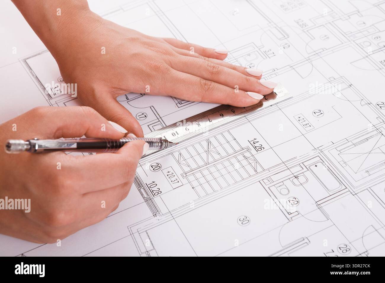 Hands Measuring a Blueprint During a Design Project in an Architectural Workspace Stock Photo