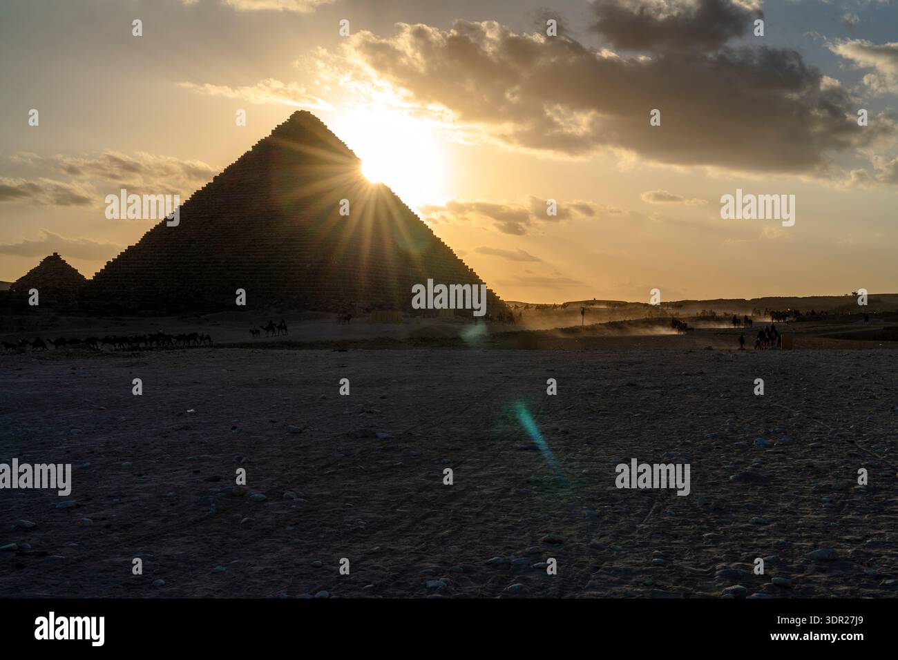 Pyramid With Sun Rays Wide view of an ancient pyramid at sunset in Cairo, Egypt, with ...