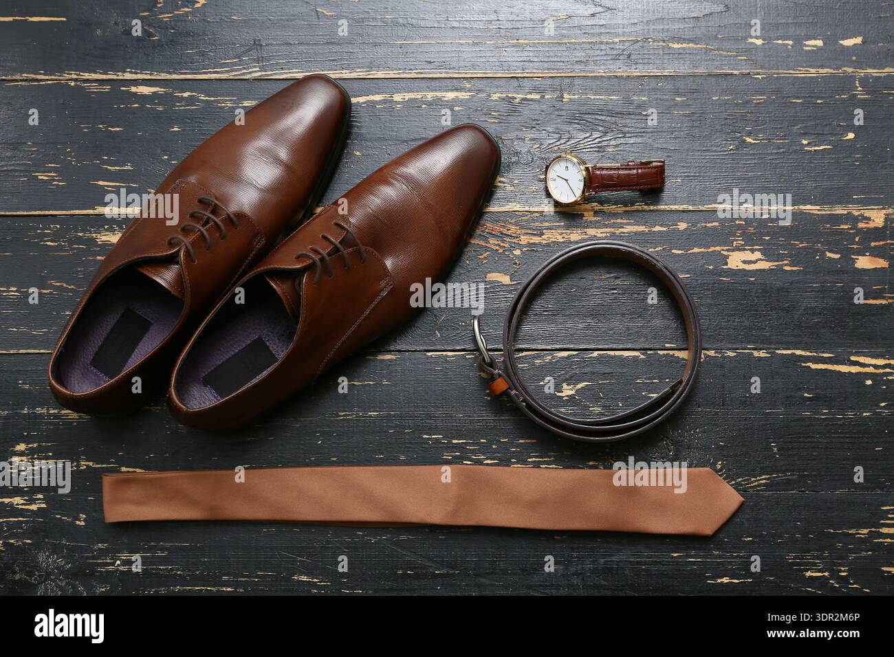 Male shoes with accessories on black wooden background Stock Photo