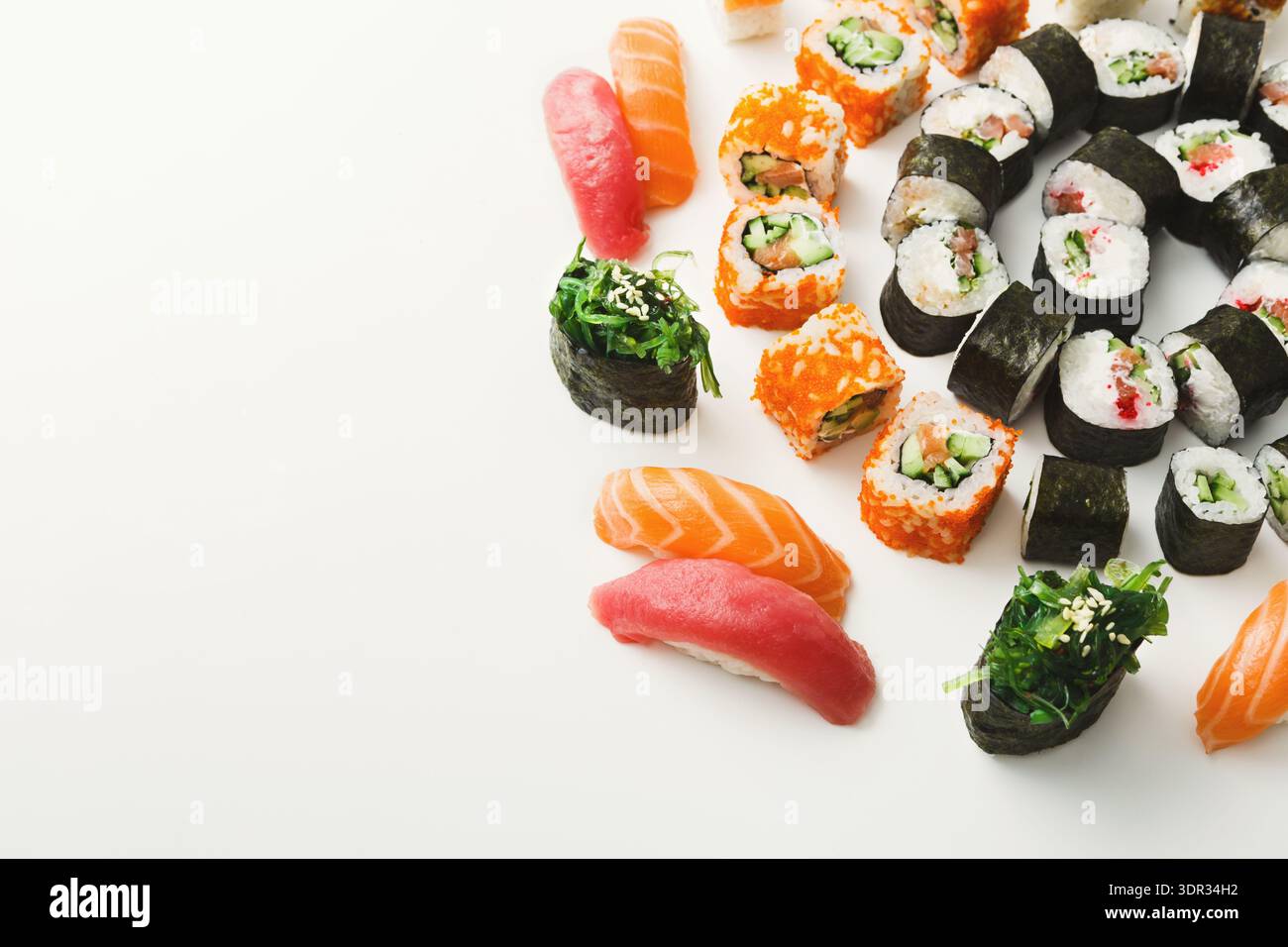 Different Types of Sushi Arranged in a Circular Pattern on a White Surface Stock Photo