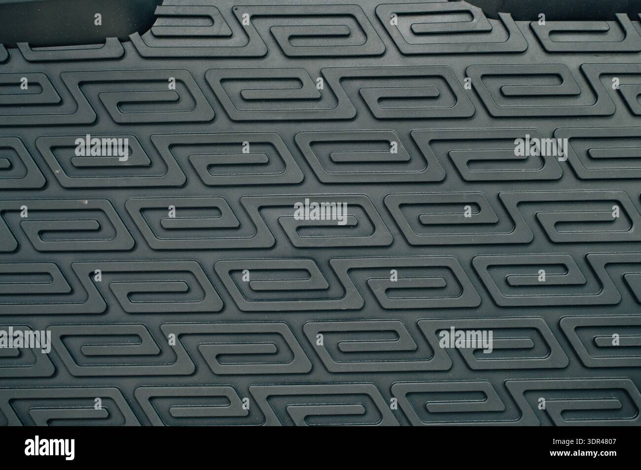 Abstract background of a dark, textured surface with a repeating geometric pattern Stock Photo