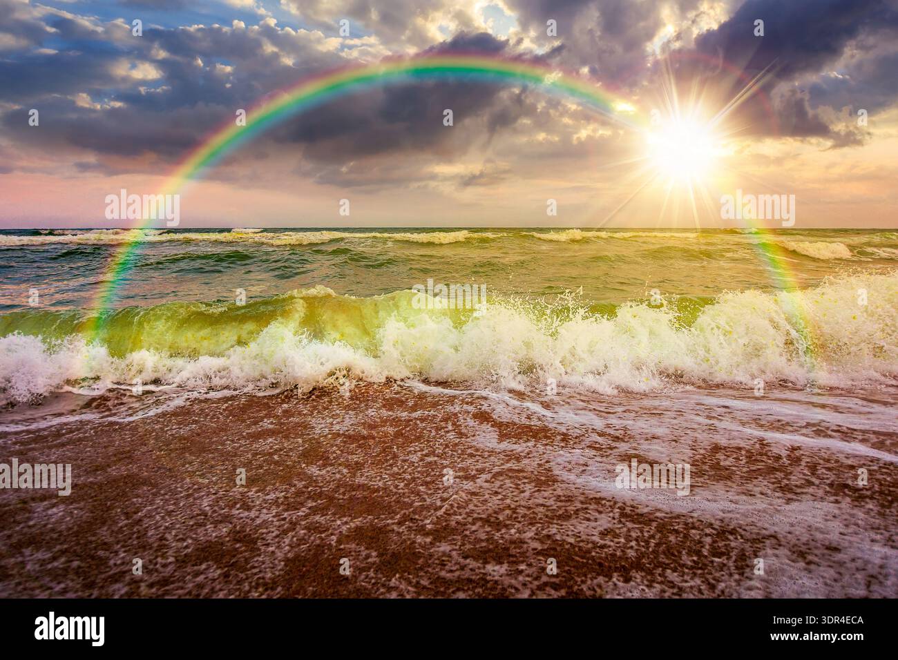 stormy weather on the sandy beach at sunset. dramatic sky over the sea in evening light. moody summer landscape. green waves crashing the shore. majes Stock Photo