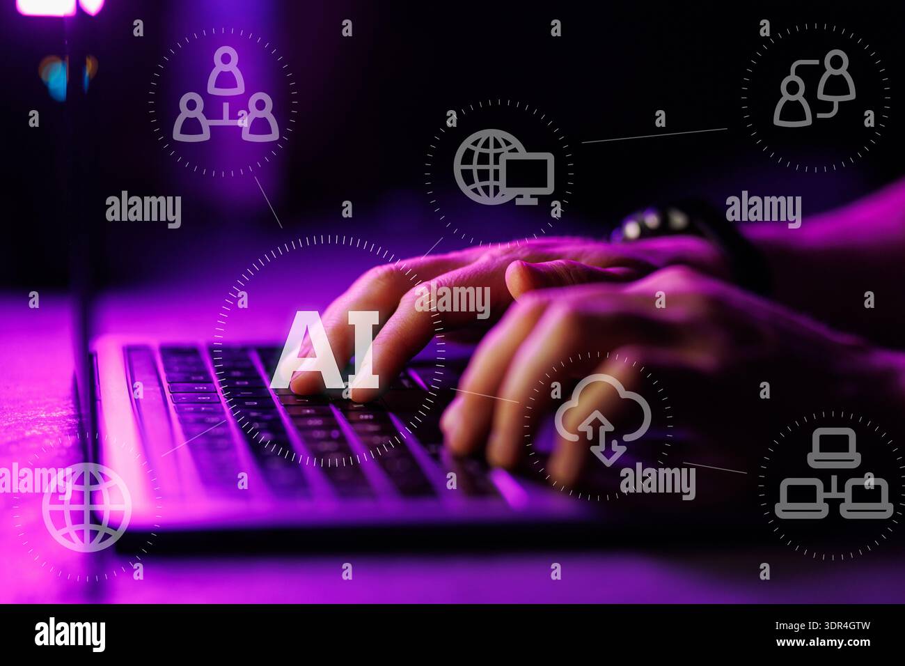 Close up of hands typing on a laptop keyboard with digital AI icons and overlays in a dark room with purple lighting, representing artificial intellig Stock Photo
