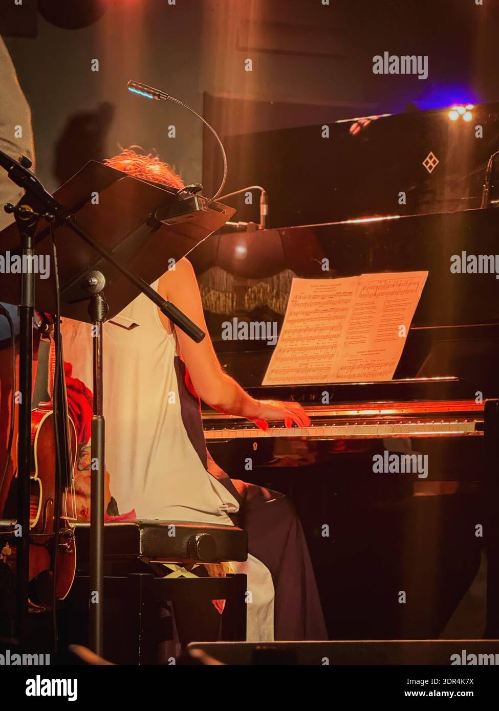Pianist performing on grand piano with sheet music and microphone on ...