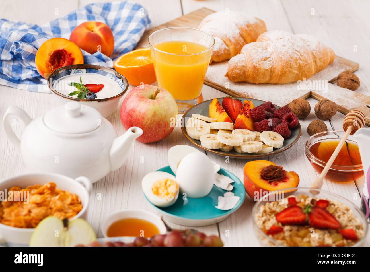 Collection of Breakfast Foods and Drinks Arranged on a Wooden Table in a Bright Setting Stock Photo