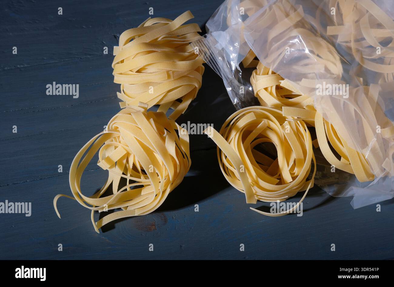 dried tagliatelle pasta in plastic packaging Stock Photo