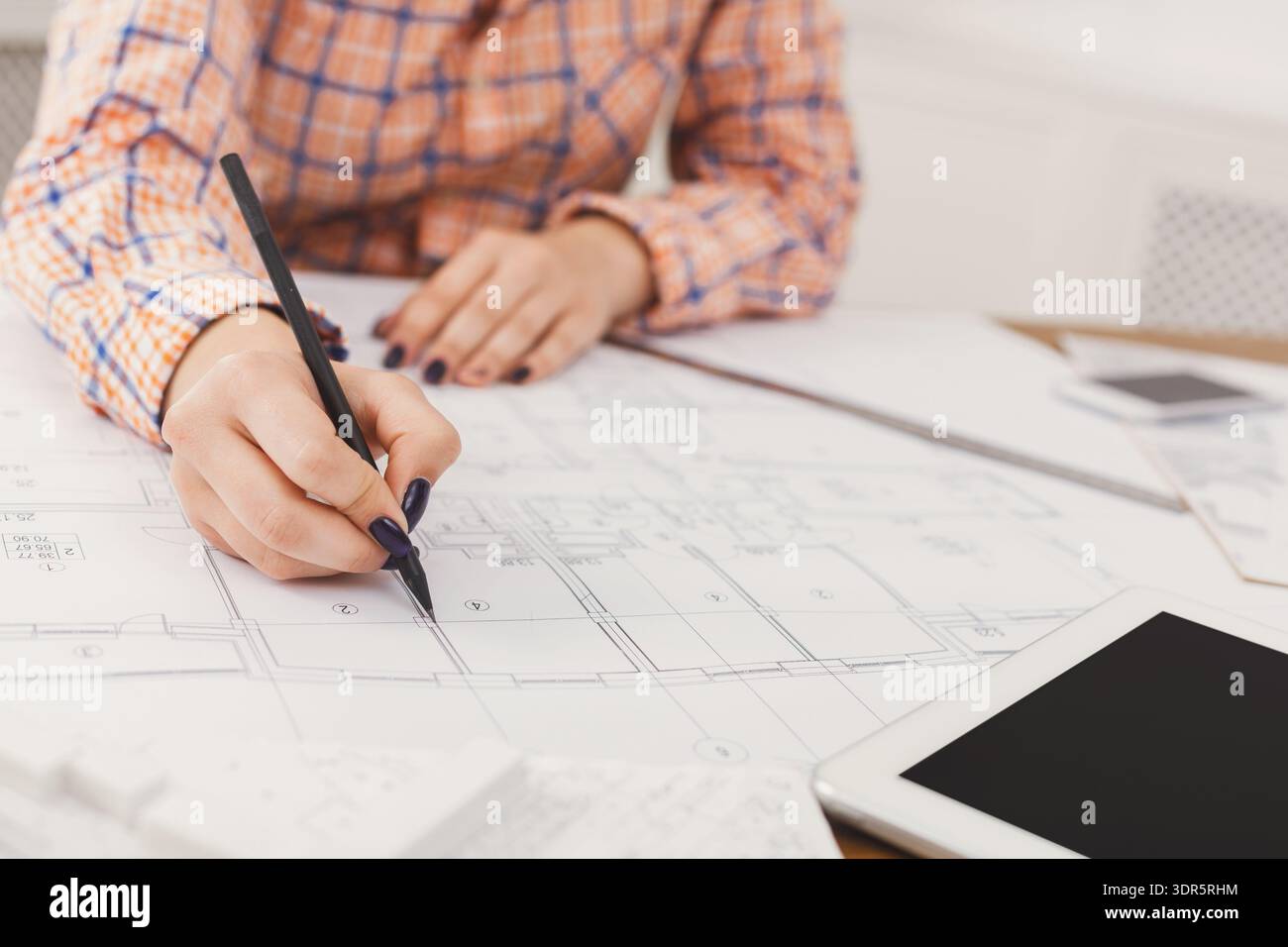 Drafting a Building Plan With a Pencil on a Large Sheet of Paper at a ...