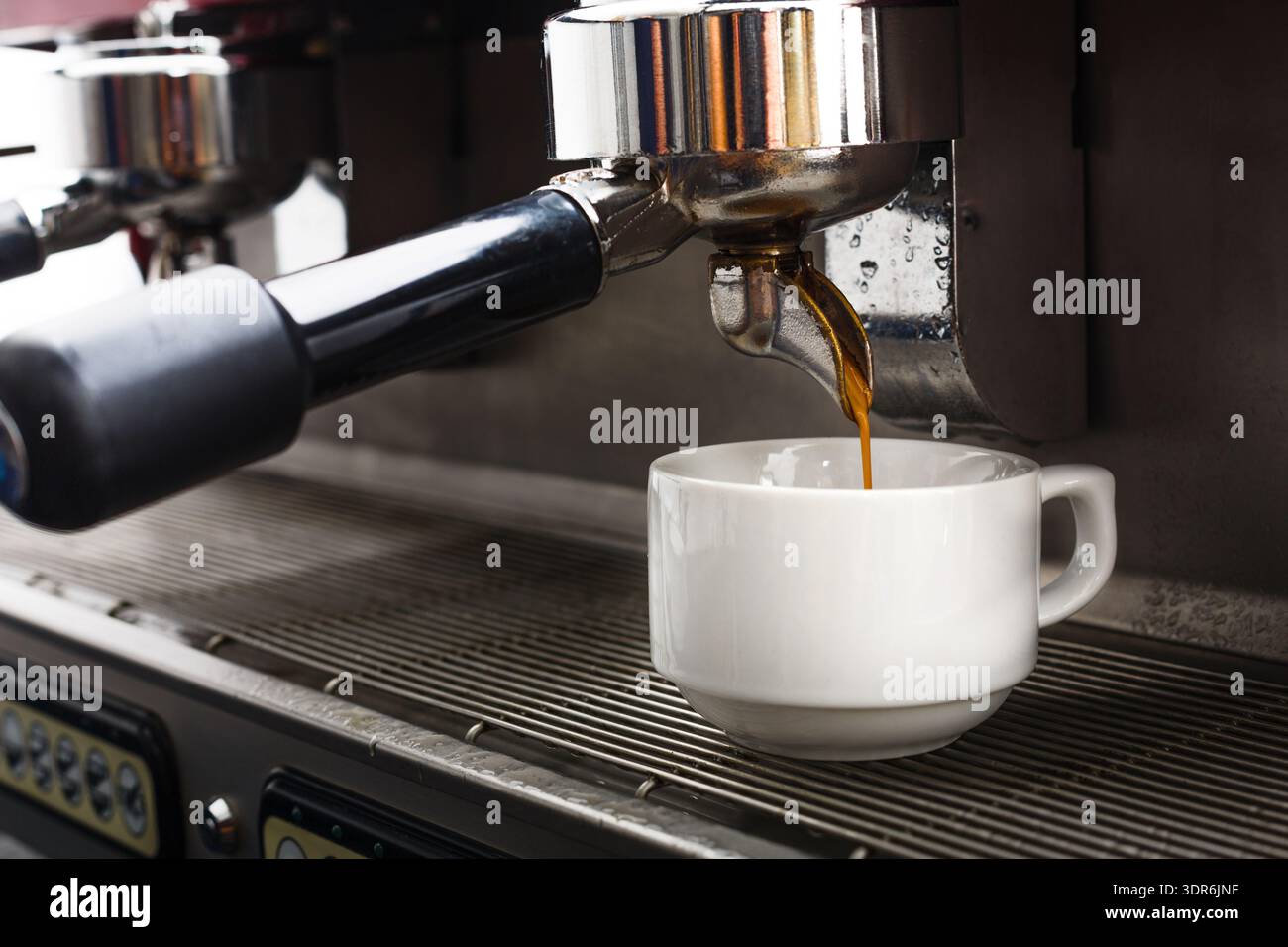 Coffee Brewing Process in a Cafe Using Espresso Machine With Cup Underneath Stock Photo