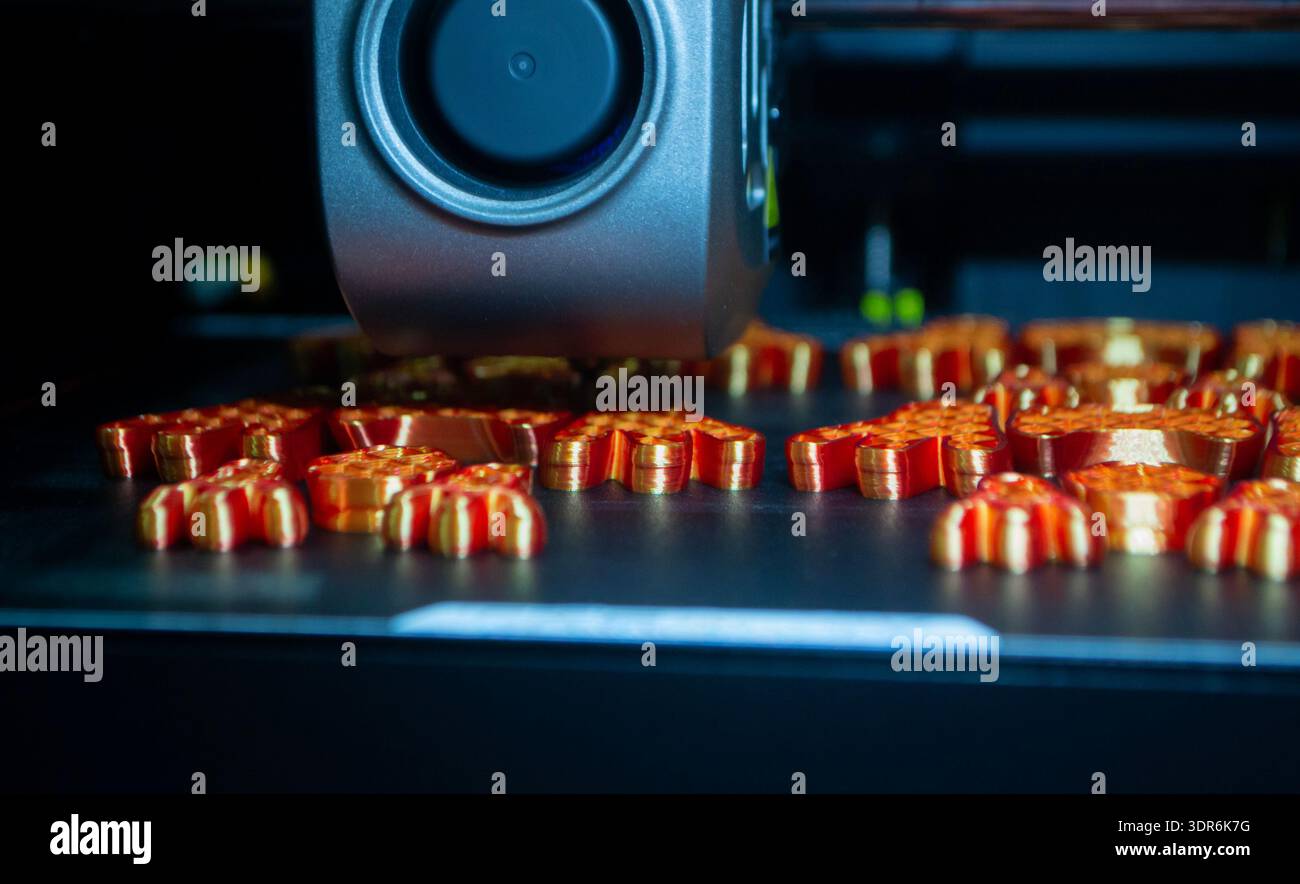 3D printer. 3D printer printing object close-up. 3D printer printing model orange color. Working 3D printer. Concept printing technology. New modern additive progressive technology. FDM technologies Stock Photo