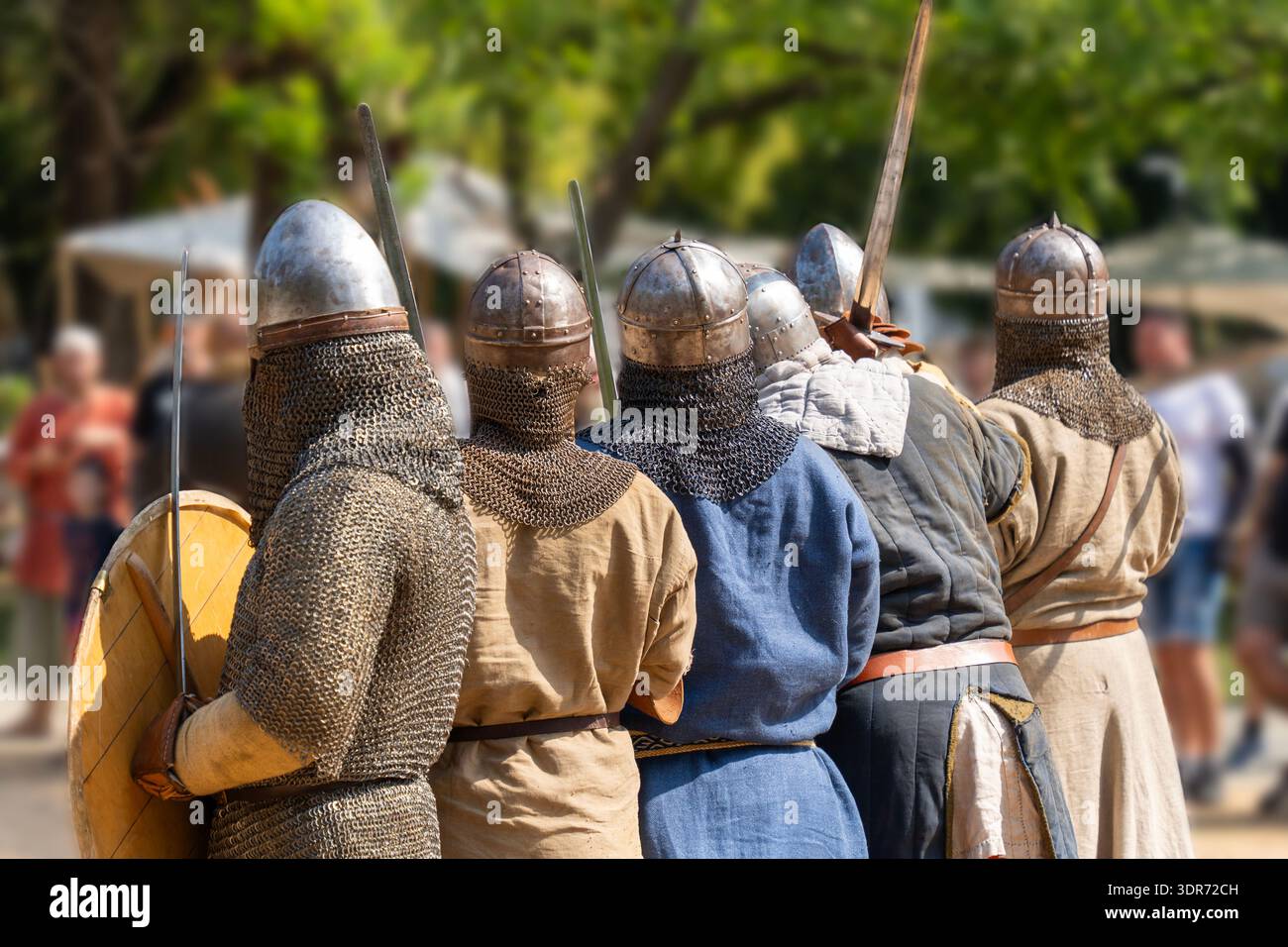 Medieval warriors in historical armor and helmets with swords in a ...