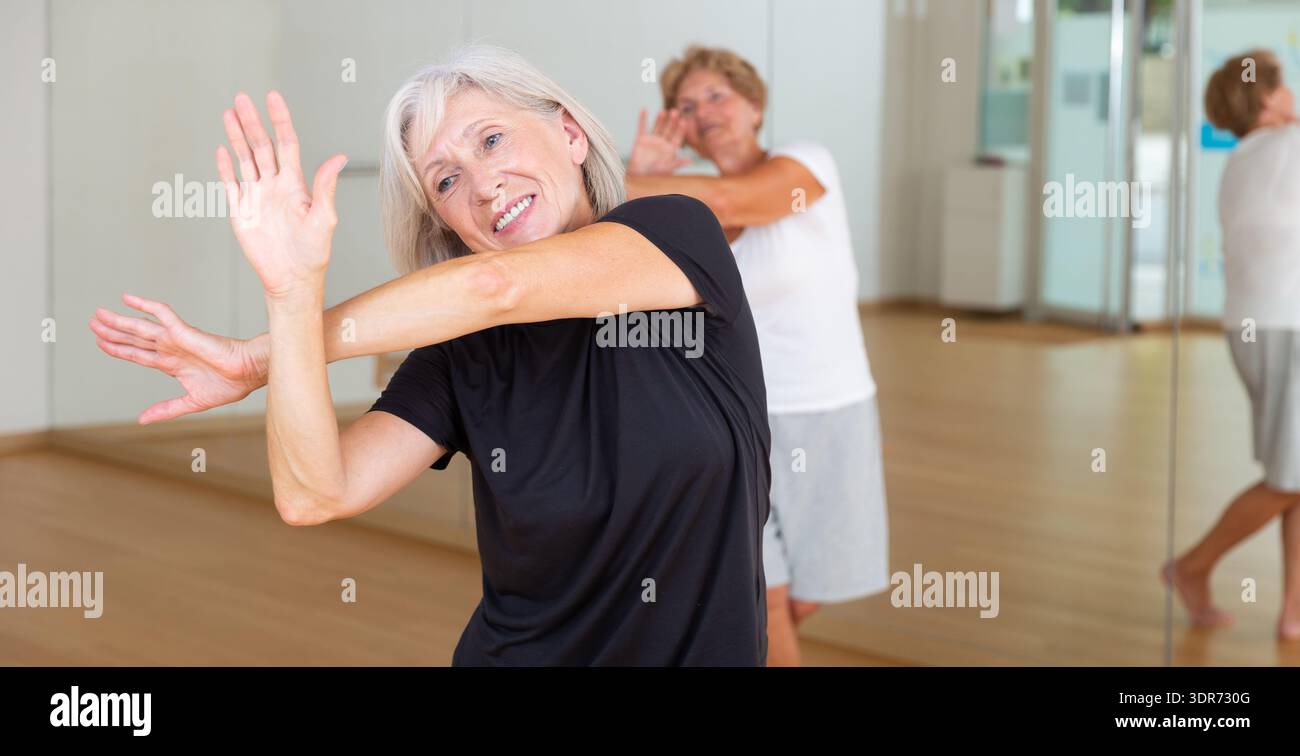 Active mature woman learning dynamic dances in choreography class Stock Photo