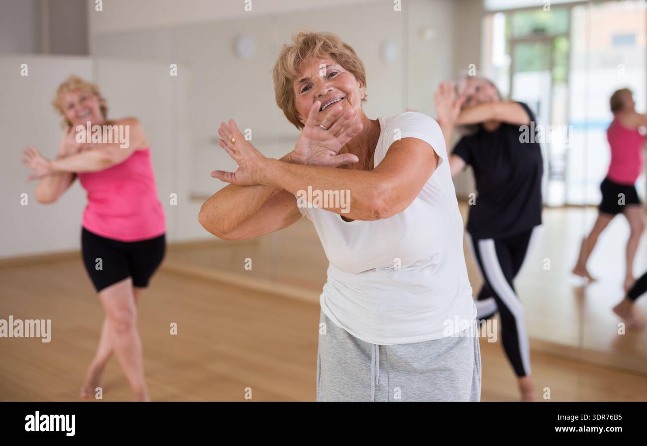 Energetic elderly woman practicing vigorous dance movements Stock Photo