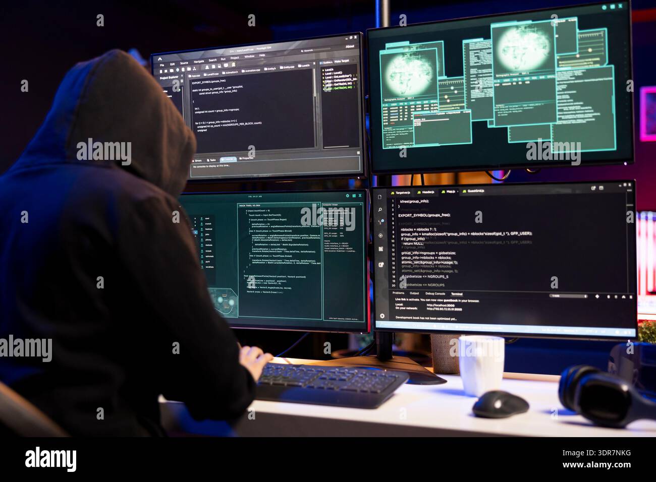 Cybercriminal coding on PC, creating stealth malware that evades security software. Hacker using programming language on computer to make script hiding malicious code from detection systems Stock Photo