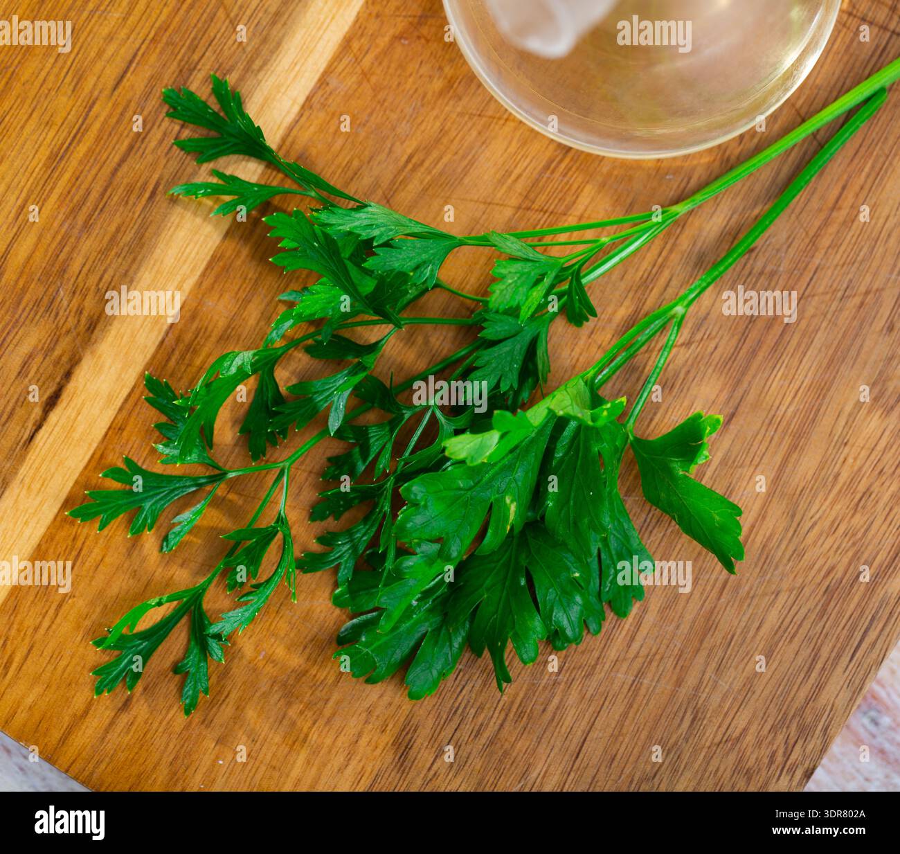 Parsley sprigs on wooden cutting board Stock Photo