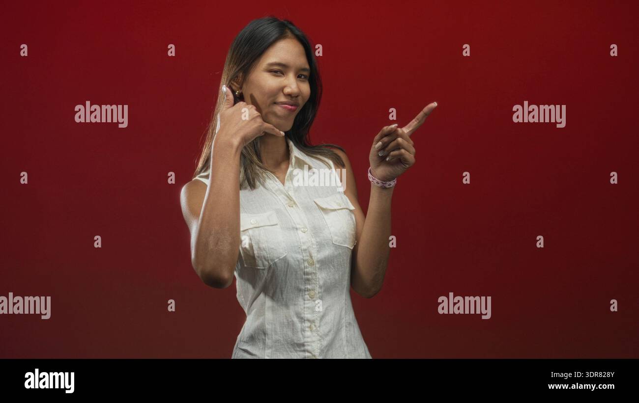 Thai woman winking and making a call me hand with thumb and pinky while ...