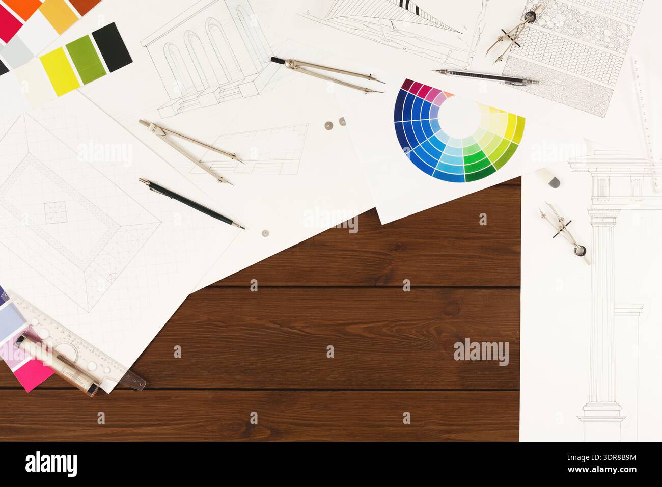 Collection of Design Drawings, Colors, and Tools Arranged on a Wooden Surface Stock Photo