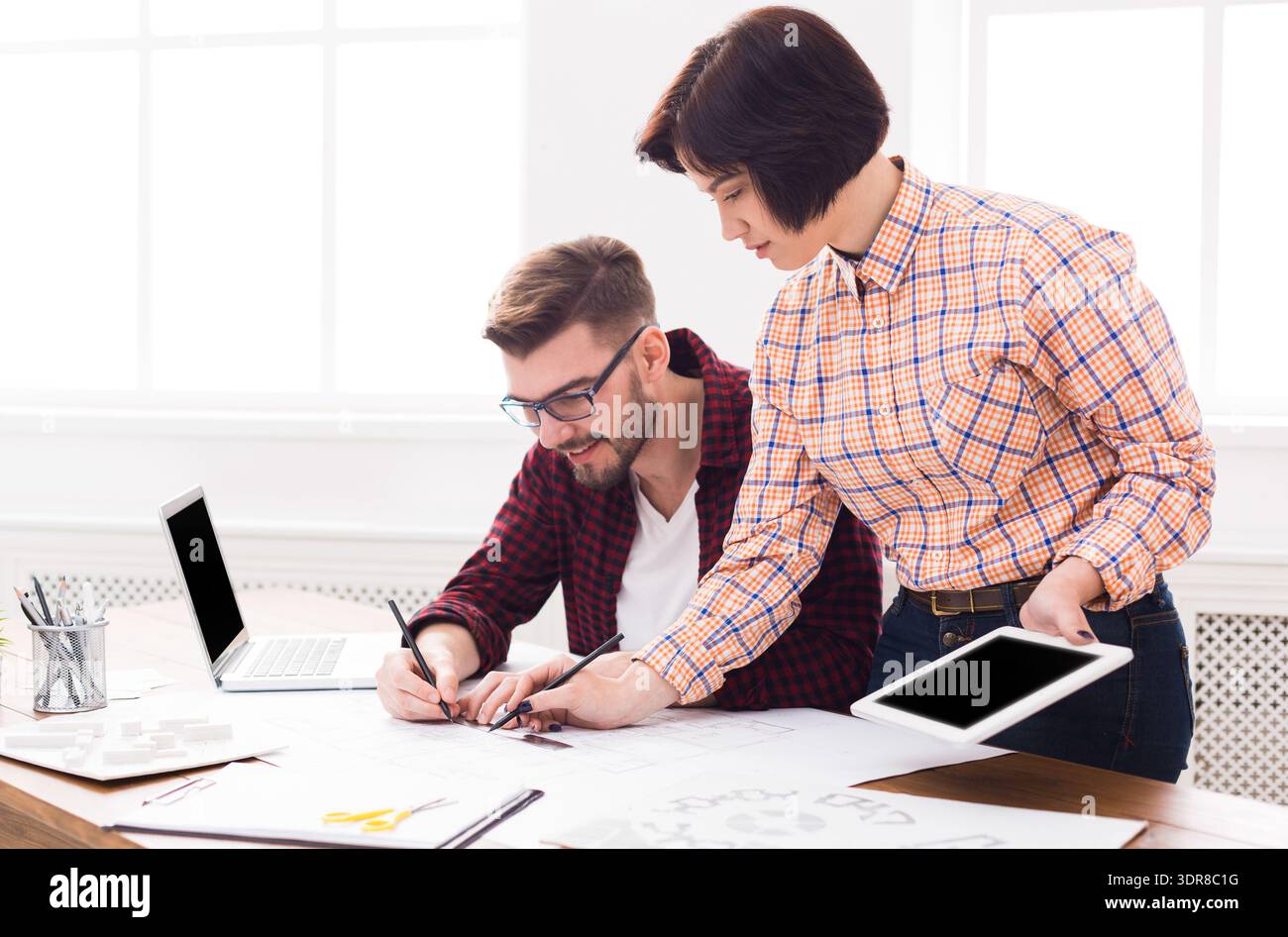 Two People Working on Design Projects in a Bright Office During Daytime Hours Stock Photo