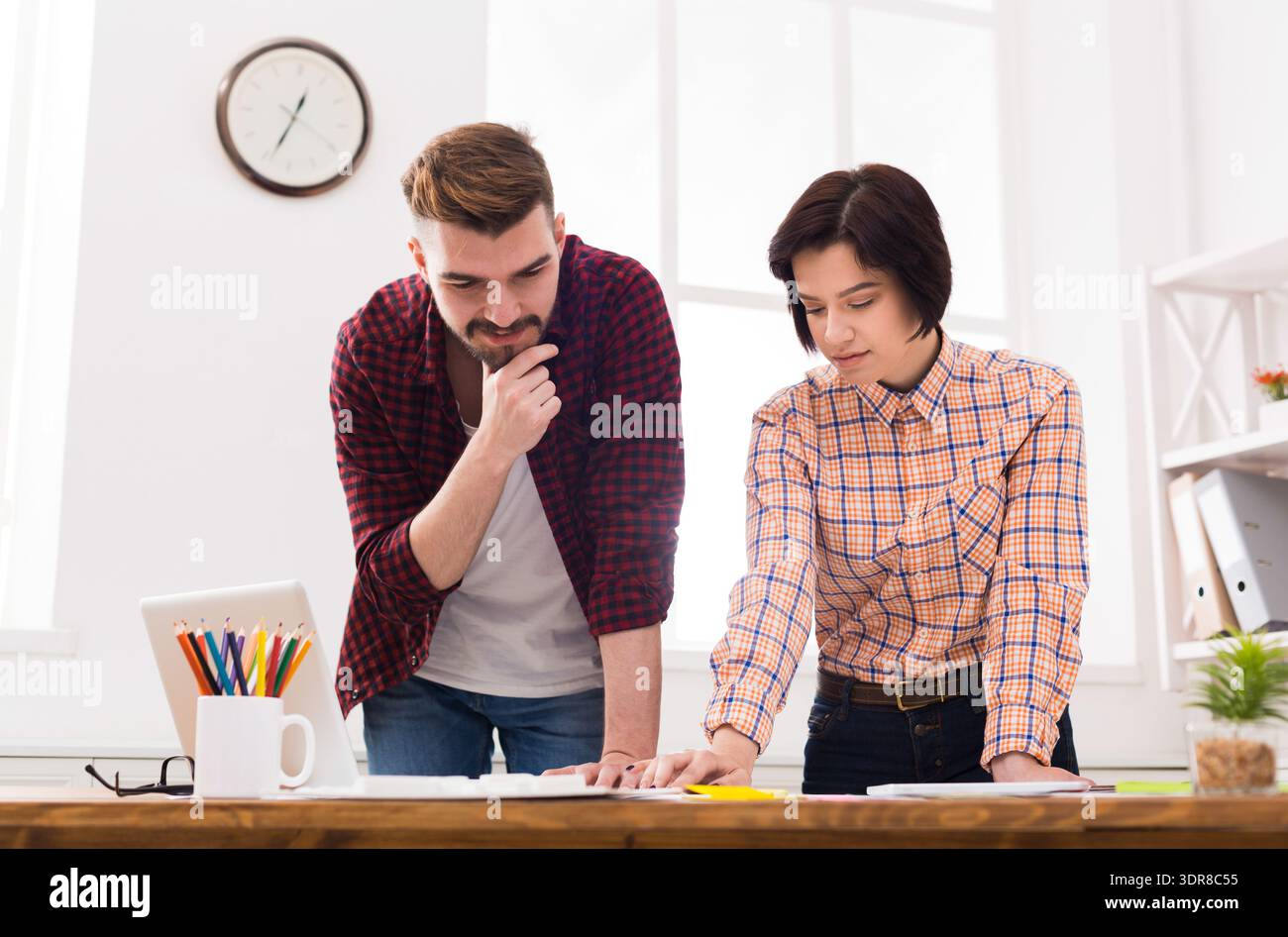 Colleagues Discussing Project Plans in a Bright Office Space During Daytime Hours Stock Photo
