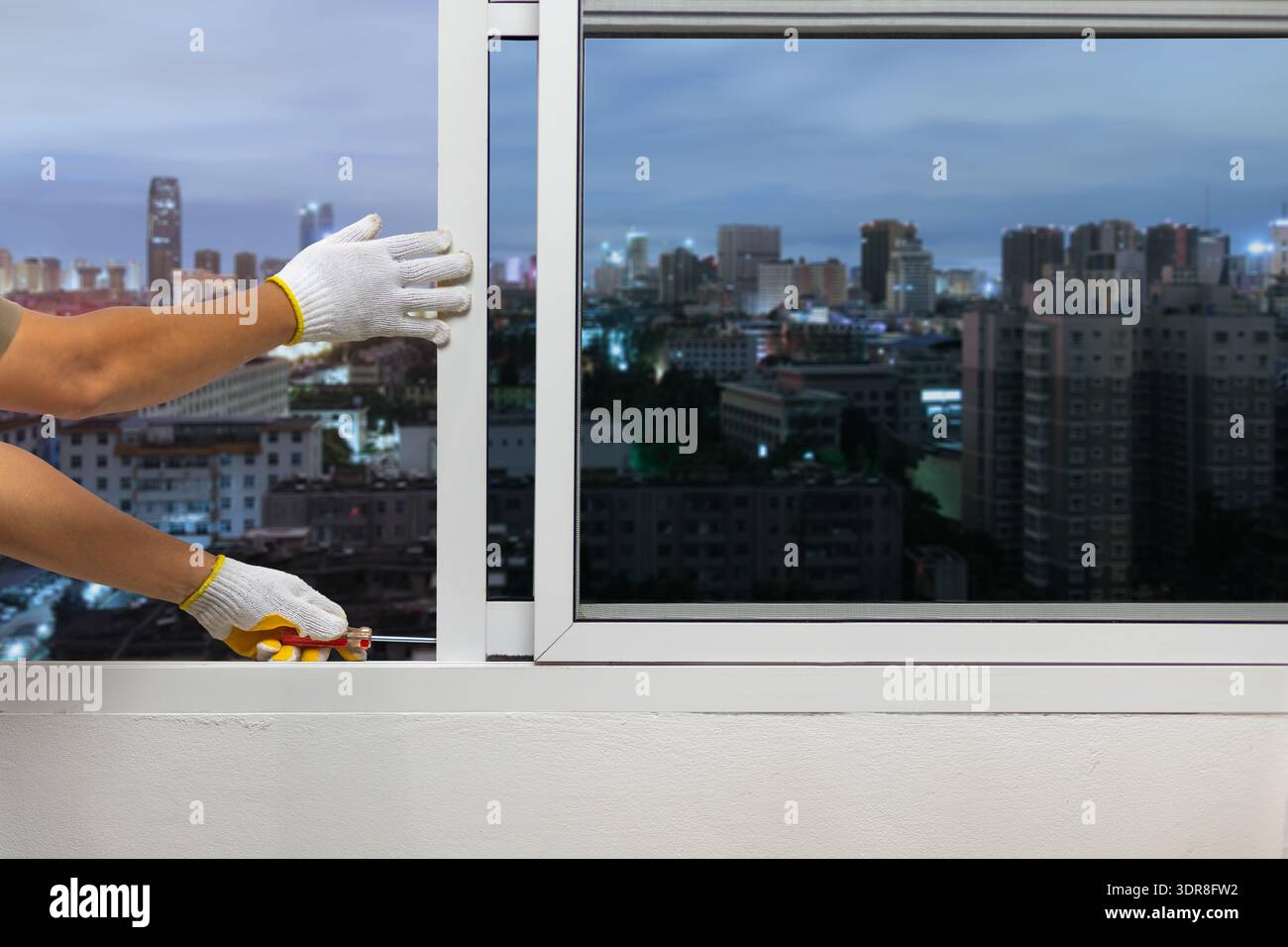 Construction worker repairing the sliding window on condominium room. Stock Photo