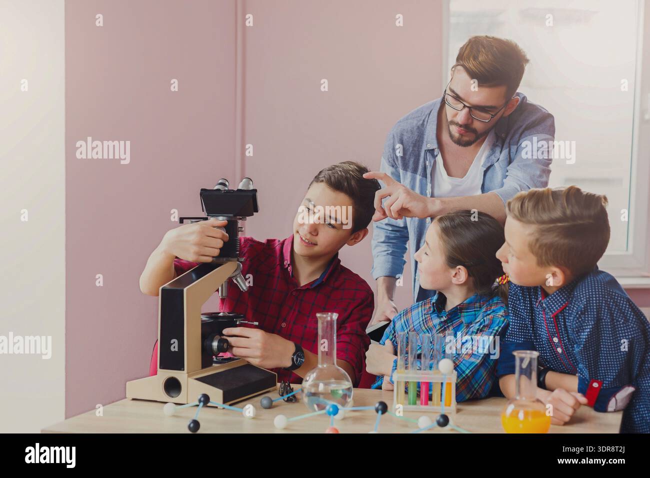 Students Learn About Microscopes During a Science Class in a Bright Classroom Setting Stock Photo