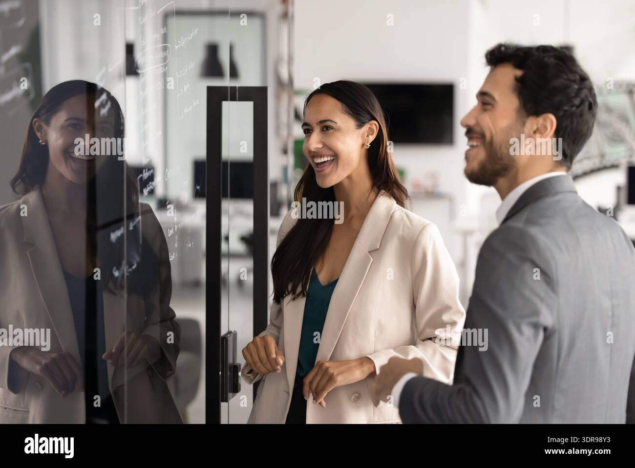 Coworkers laughing while planning project in modern office Stock Photo