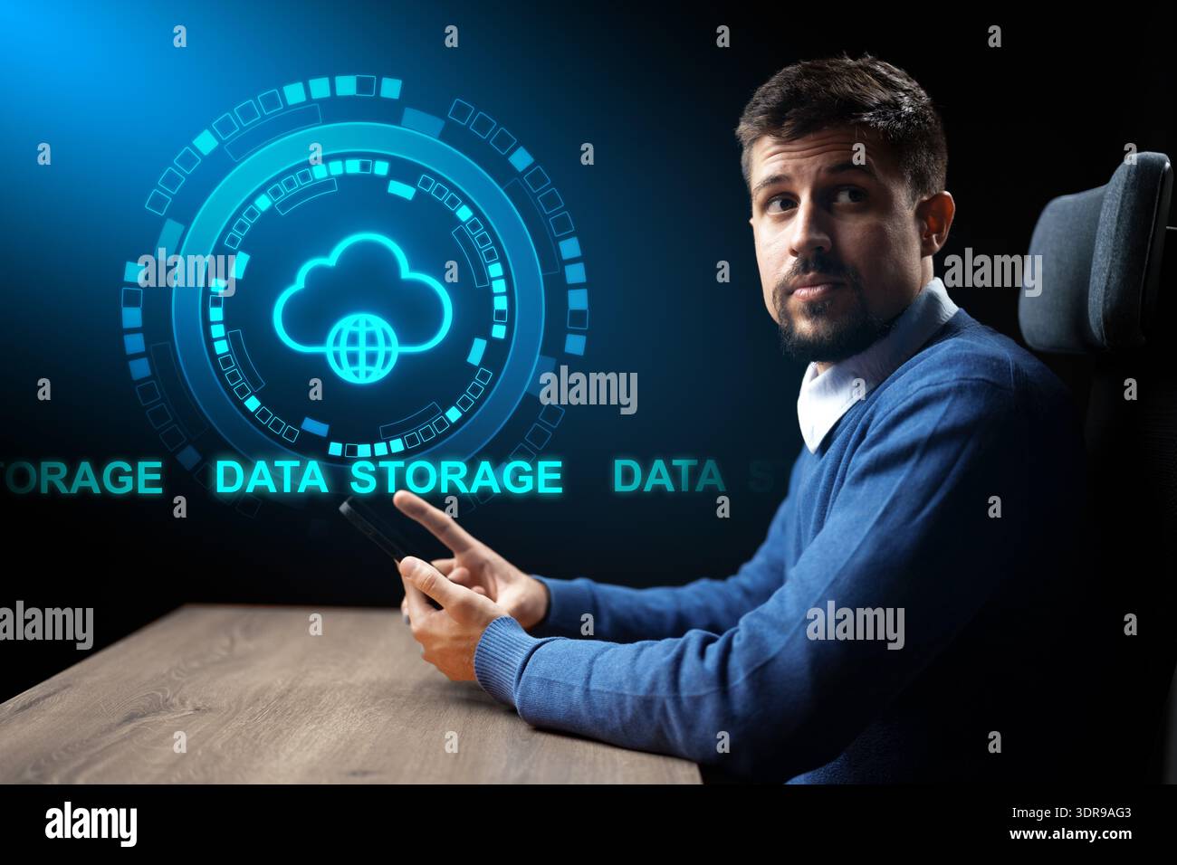Man using smartphone with cloud data storage graphic at his workplace Stock Photo