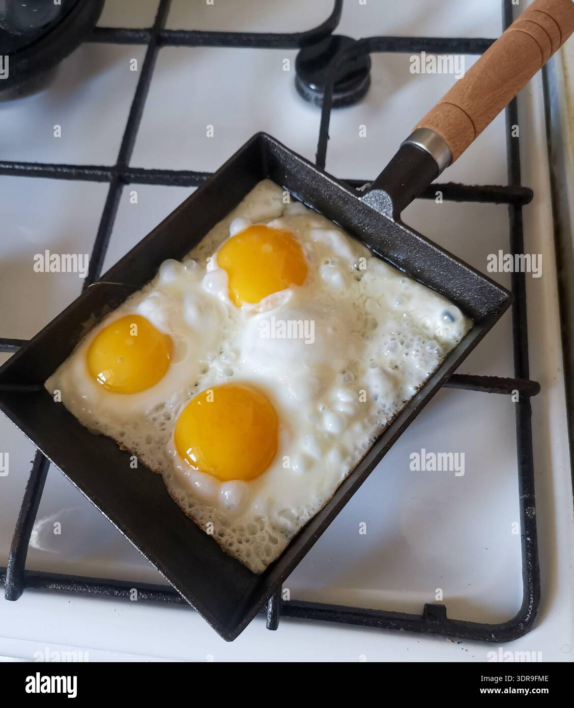 Fried eggs in cast iron pan Stock Photo