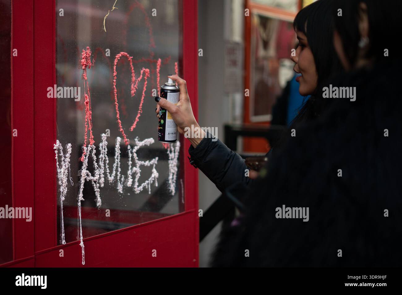 New York, United States. 17th Feb, 2026. A woman writes a message in ...