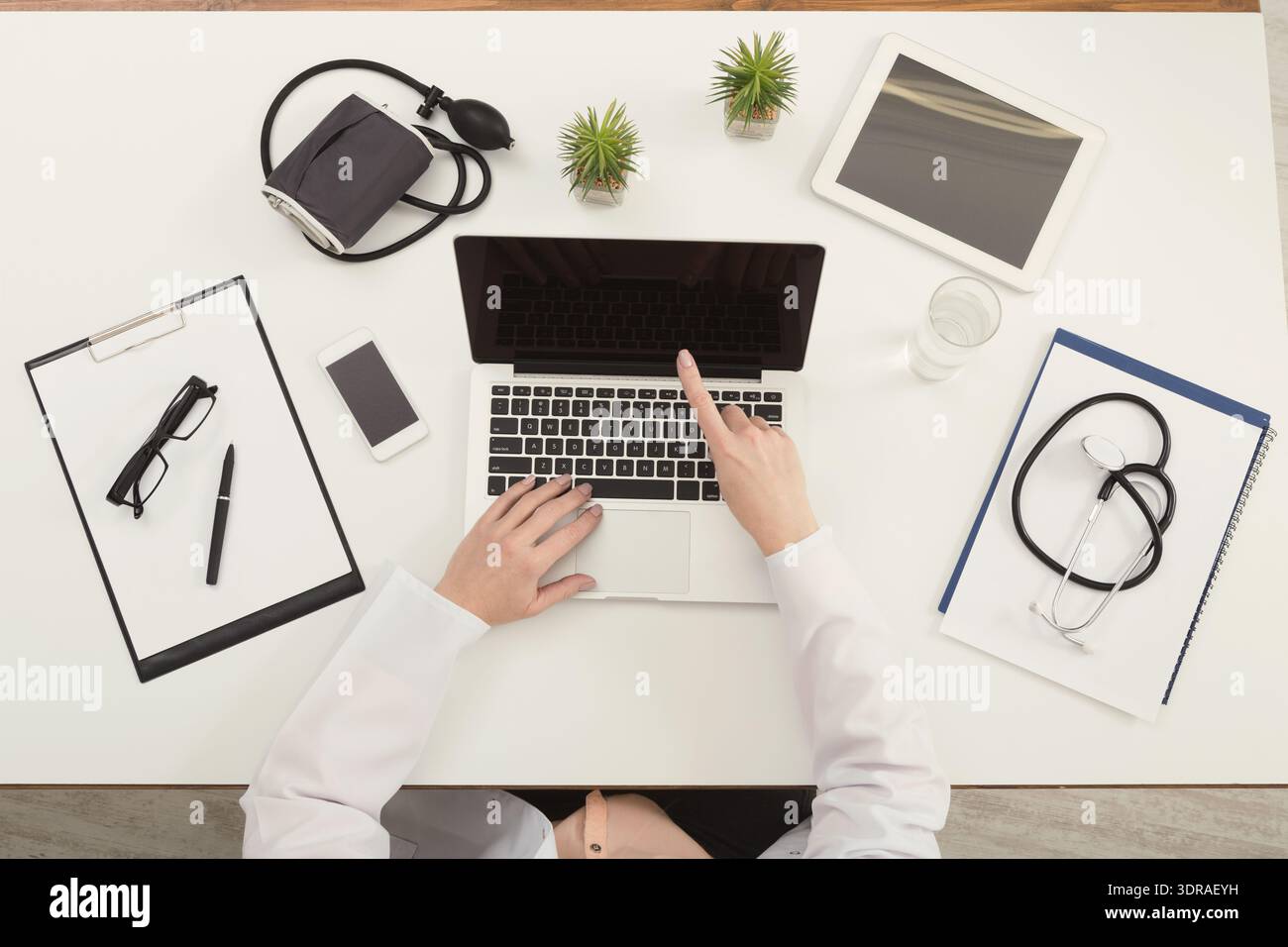 Exploring Health Data on Laptop While Surrounded by Medical Tools and Devices Stock Photo