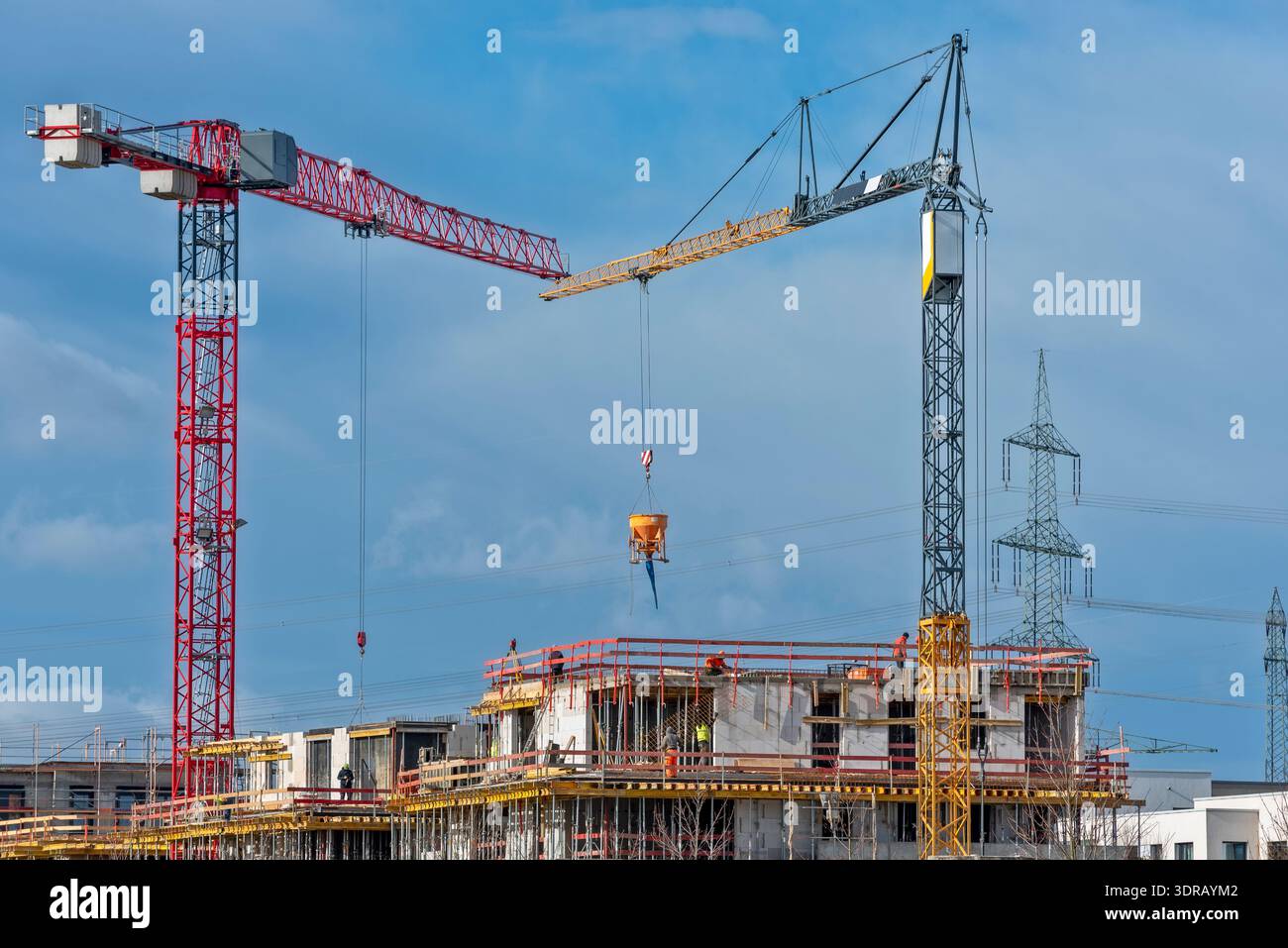 Two construction cranes on the building site of a house Stock Photo