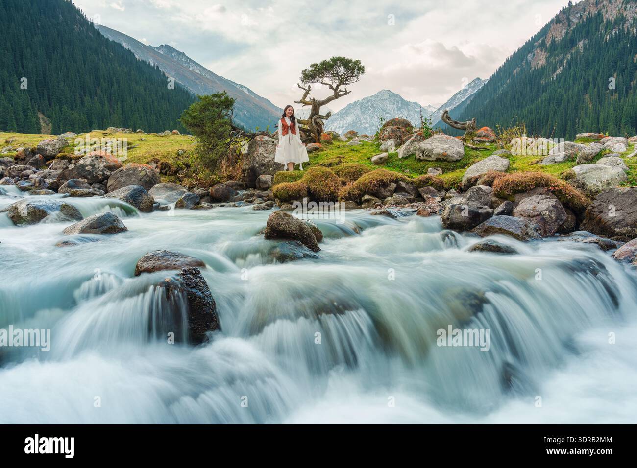 Asian female traveler in traditional dress by flowing river with iconic ...