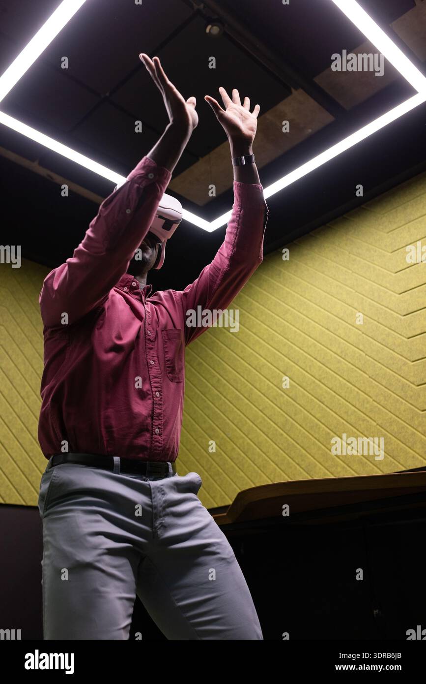 Using VR headset, man in business attire interacting with virtual environment Stock Photo