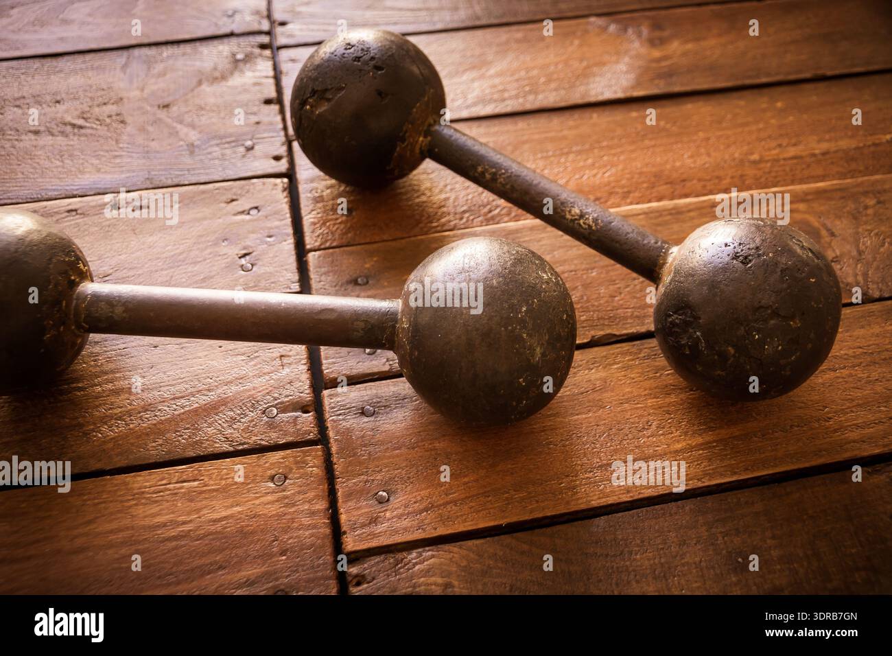 Old rusty dumbbells on wood background texture Stock Photo
