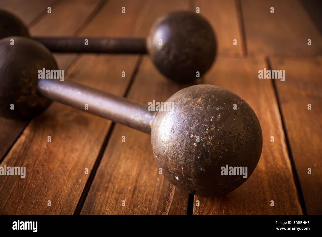 Old rusty dumbbells on wood background texture Stock Photo