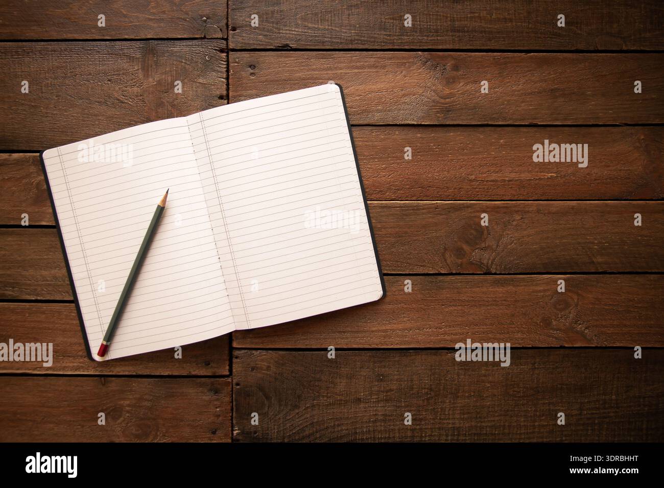 Open notebook and pencil on a rustic wooden board Stock Photo