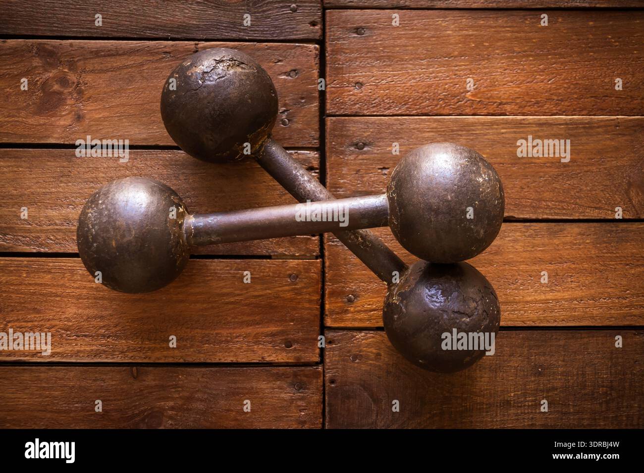 Old rusty dumbbells on wood background texture Stock Photo