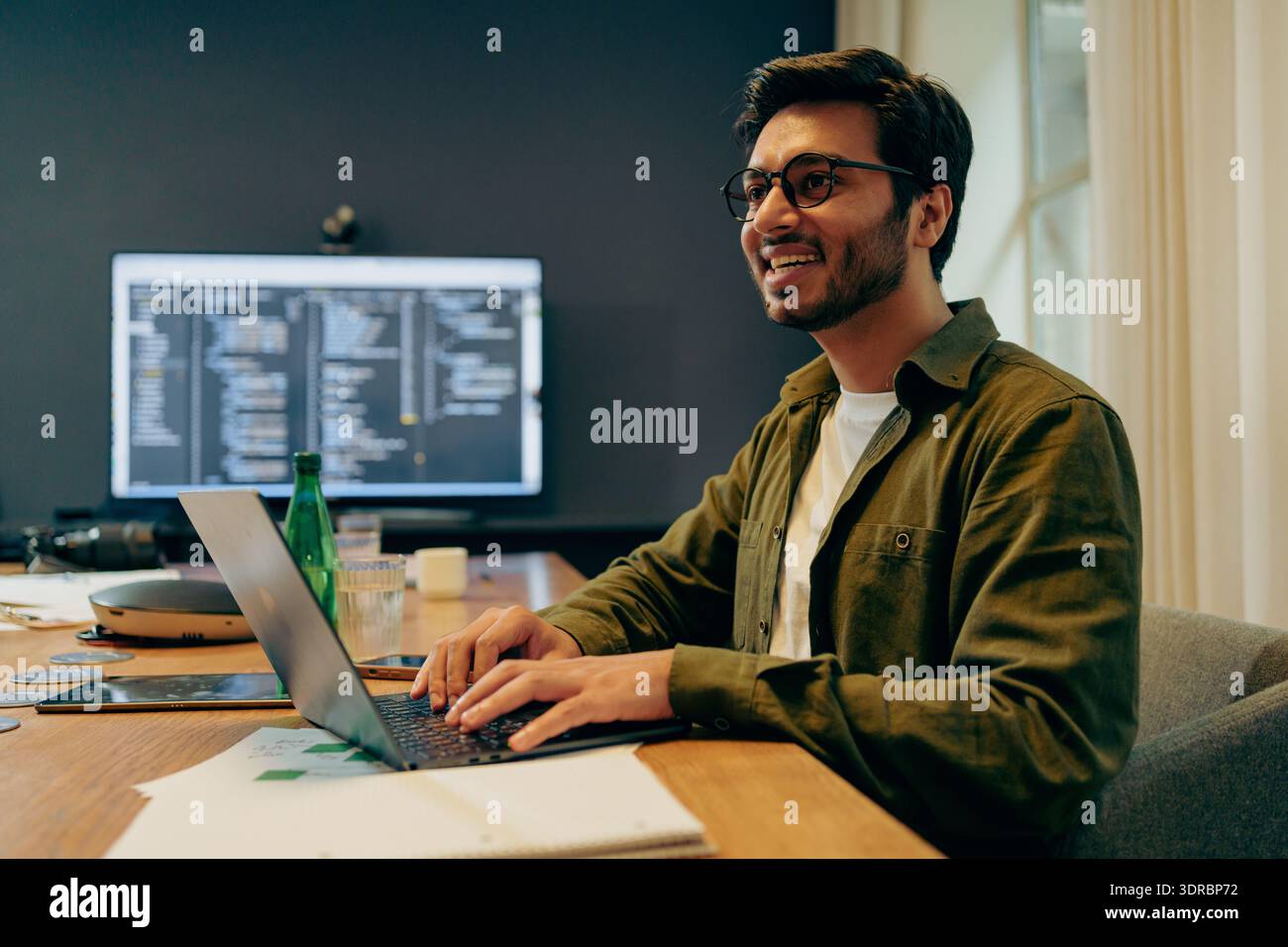 Casual Dressed Programmer Concentrating On Programming On Multiple Monitors In Bright Home Office Environment Stock Photo