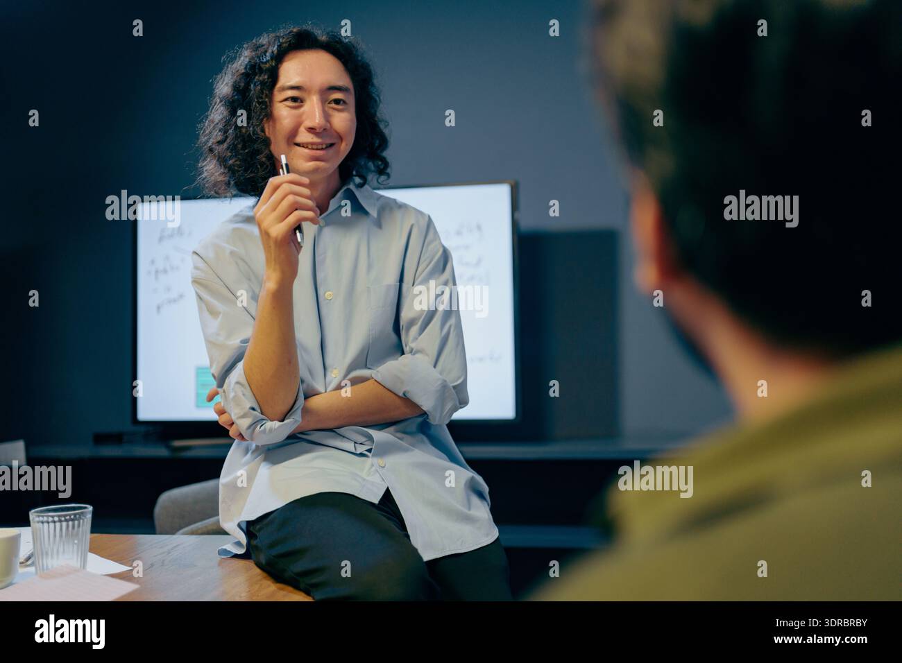 enthusiastic asian creative director engaging in collaborative design discussion at workspace Stock Photo
