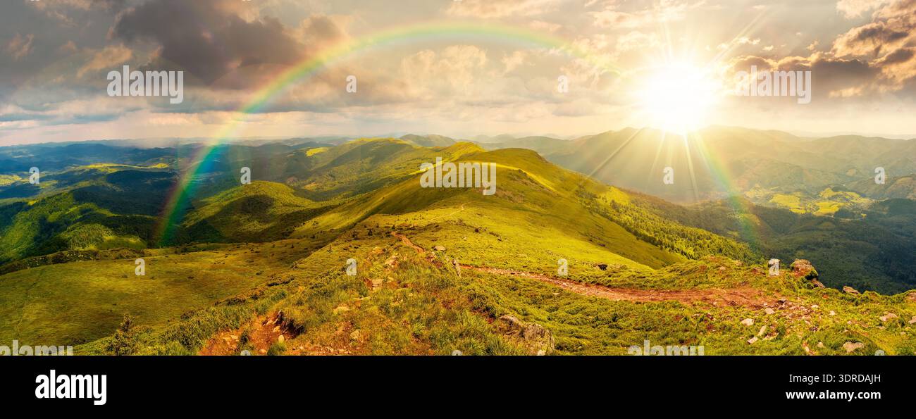 beautiful landscape of mountainous area on a summer sunset. panoramic view of great ridge in dappled evening light. alpine scenery with path through g Stock Photo