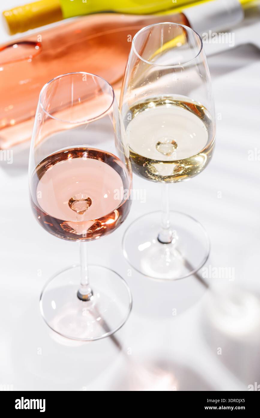 Two wine glasses filled with rose and white wine Stock Photo
